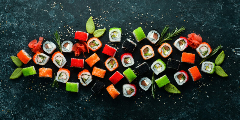 big-set-pieces-sushi-rolls-black-stone-background-top-view-free-space-your-text Big set of pieces of sushi rolls on black stone background. Top view. Free space for your text.
